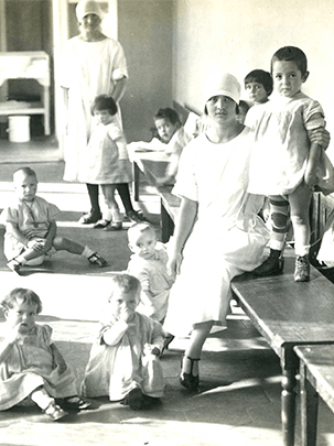 Gruppo di donne con bambini in un interno dell'Istituto degli Innocenti